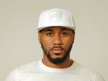 Unisex all-white cap with tonal embroidery, curved brim, and adjustable back strap for a clean and versatile everyday look