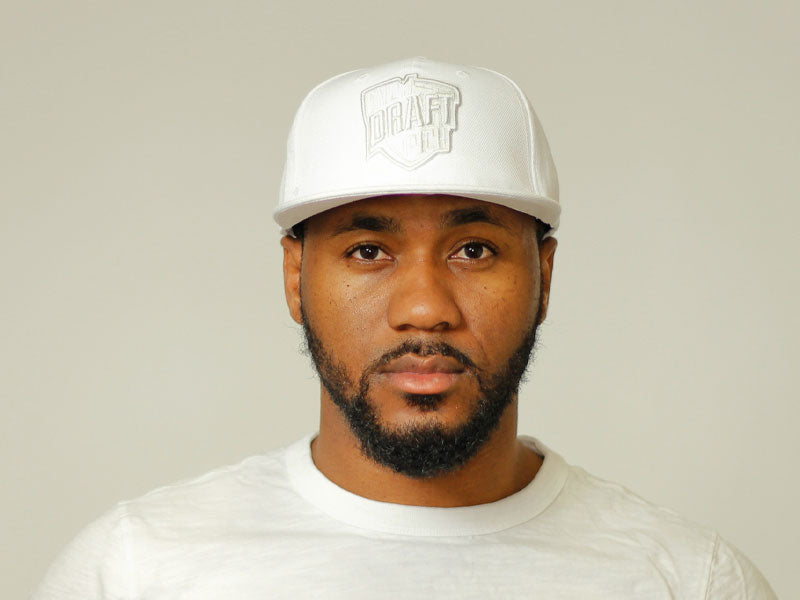 Unisex all-white cap with tonal embroidery, curved brim, and adjustable back strap for a clean and versatile everyday look